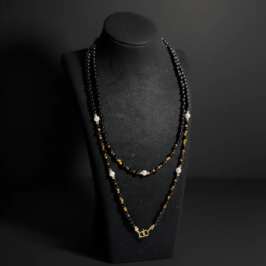 Black agate eyewear chain displayed as a necklace on a jewelry stand, handmade gemstone craftsmanship by Oculux Jewelry.