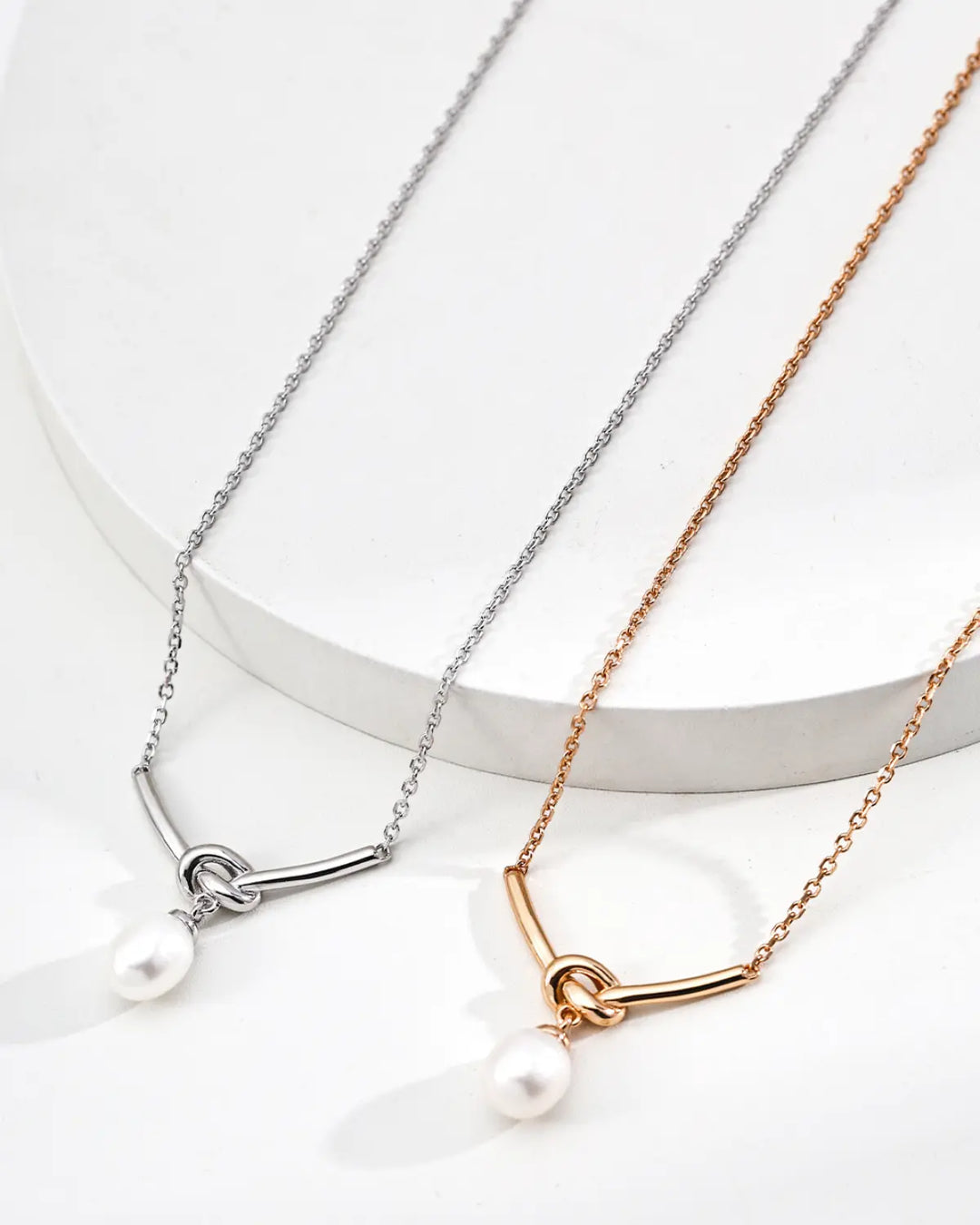 Quiet Knot pearl necklace in gold and silver versions