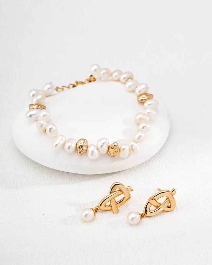 Quiet Knot pearl stud earrings styled with pearl bracelet