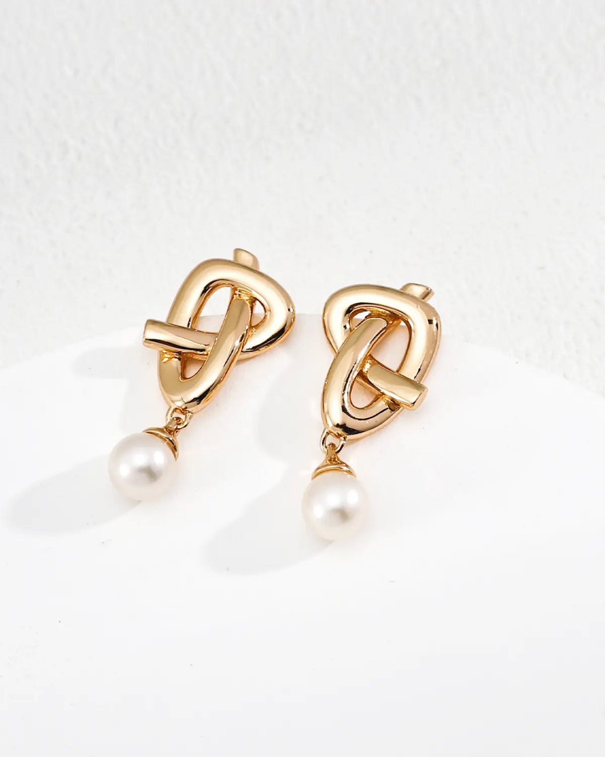 Quiet Knot freshwater pearl stud earrings with gold knot design