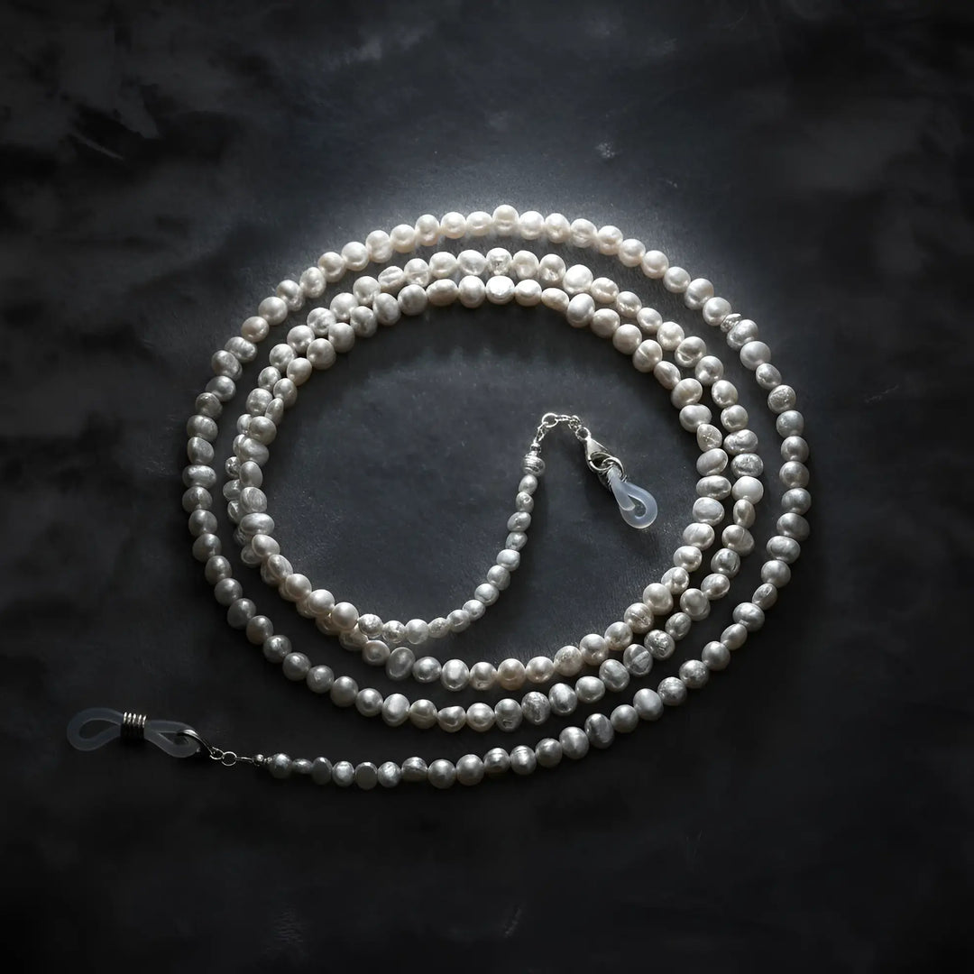 Baroque pearl eyeglass chain displayed on velvet background, highlighting irregular natural pearls and elegant craftsmanship by Oculux Jewelry.