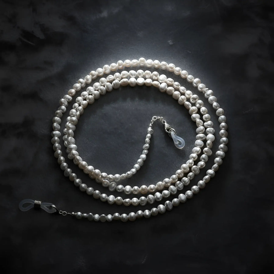 Baroque pearl eyeglass chain displayed on velvet background, highlighting irregular natural pearls and elegant craftsmanship by Oculux Jewelry.