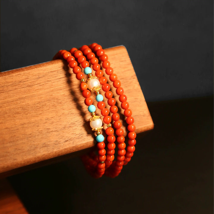 Red agate wrap bracelet version of the eyewear chain displayed on wooden stand, elegant and energetic multi-functional jewelry by Oculux Jewelry.