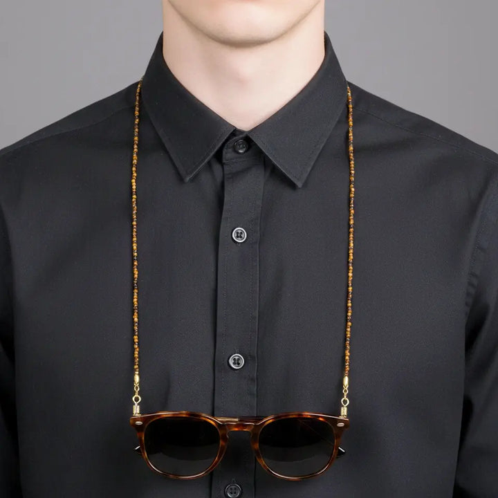 Pharaoh’s Vision tiger eye eyewear chain worn around the neck like a necklace, showing warm golden gemstone hues and a confident, versatile look.